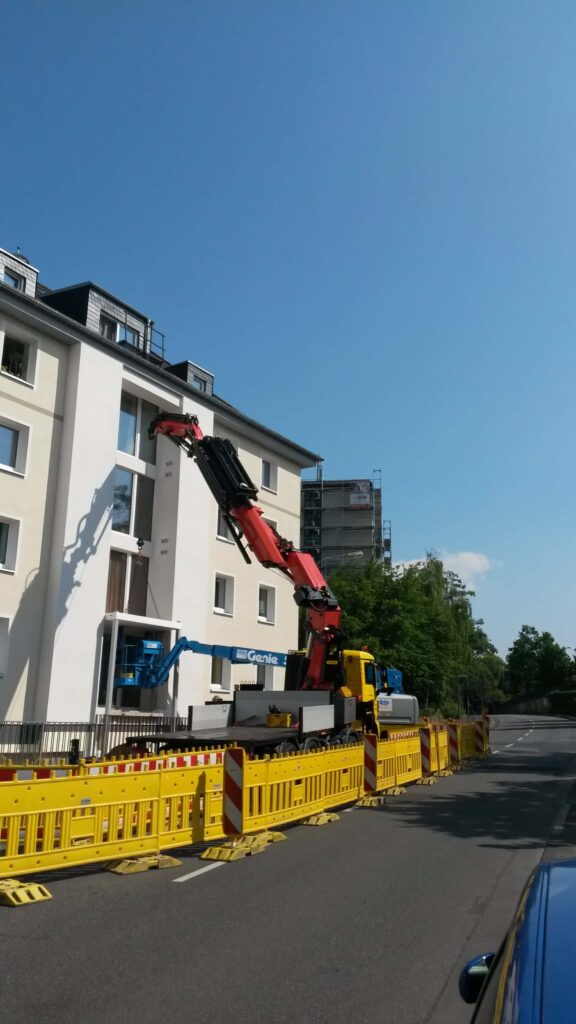 Kran hebt Bauteile über ein Gebäude