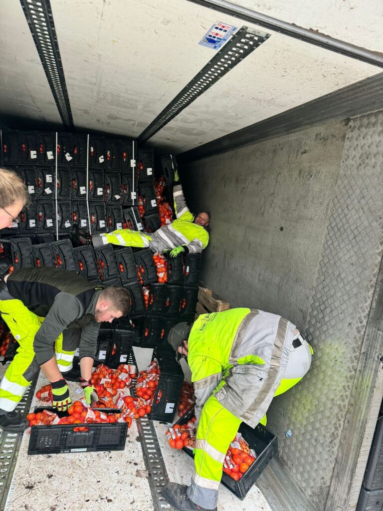 Mitarbeiter von Kran-Burgard laden die Ladung aus einem verunfallten Kühlkoffer um