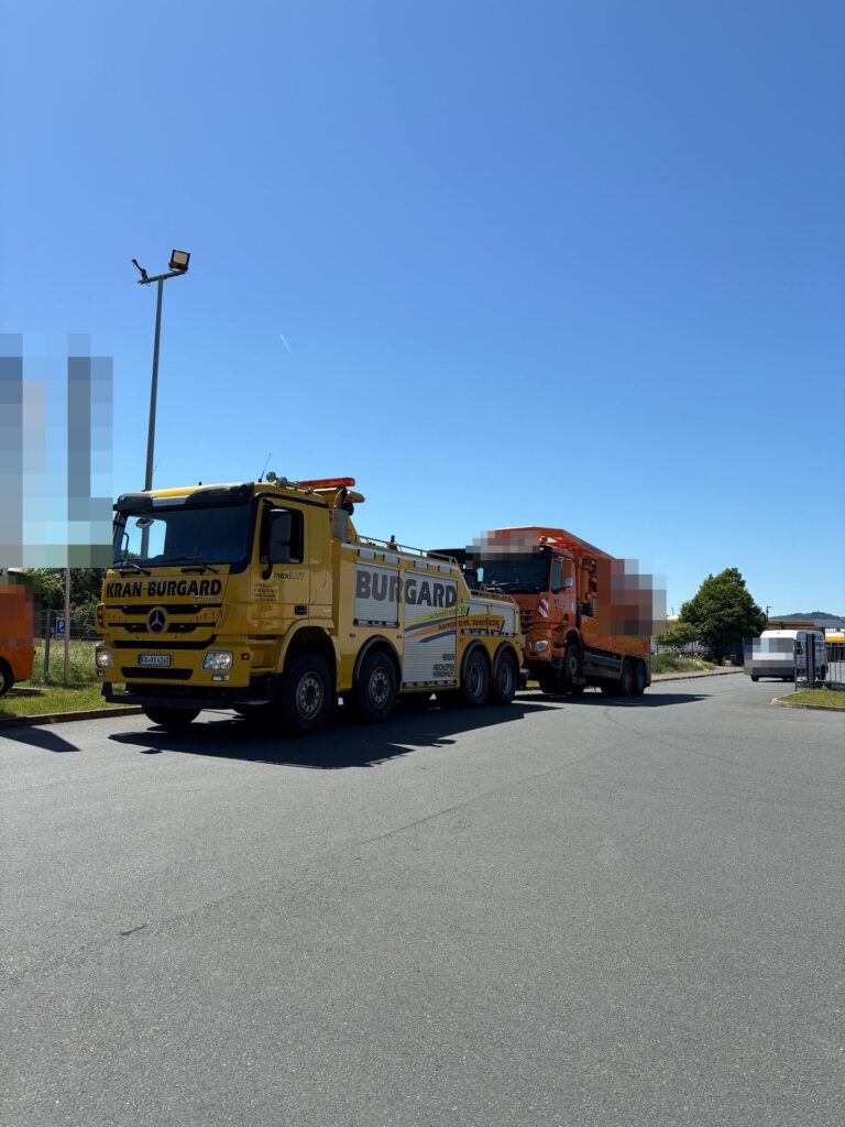 Schweres Abschleppfahrzeug von Kran-Burgard mit Lkw im Schlepp