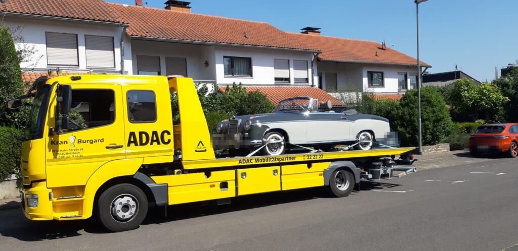 Plateaufahrzeug von Kran-Burgard transportiert einen Oldtimer